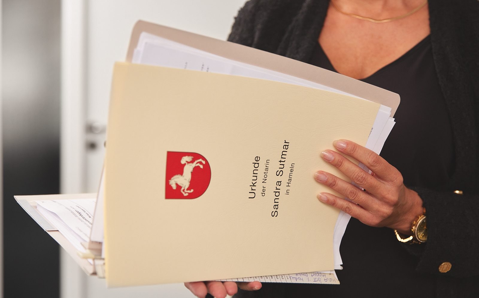 Notarielle Urkunde in einer Mappe mit Siegel in der Hand der Notarin