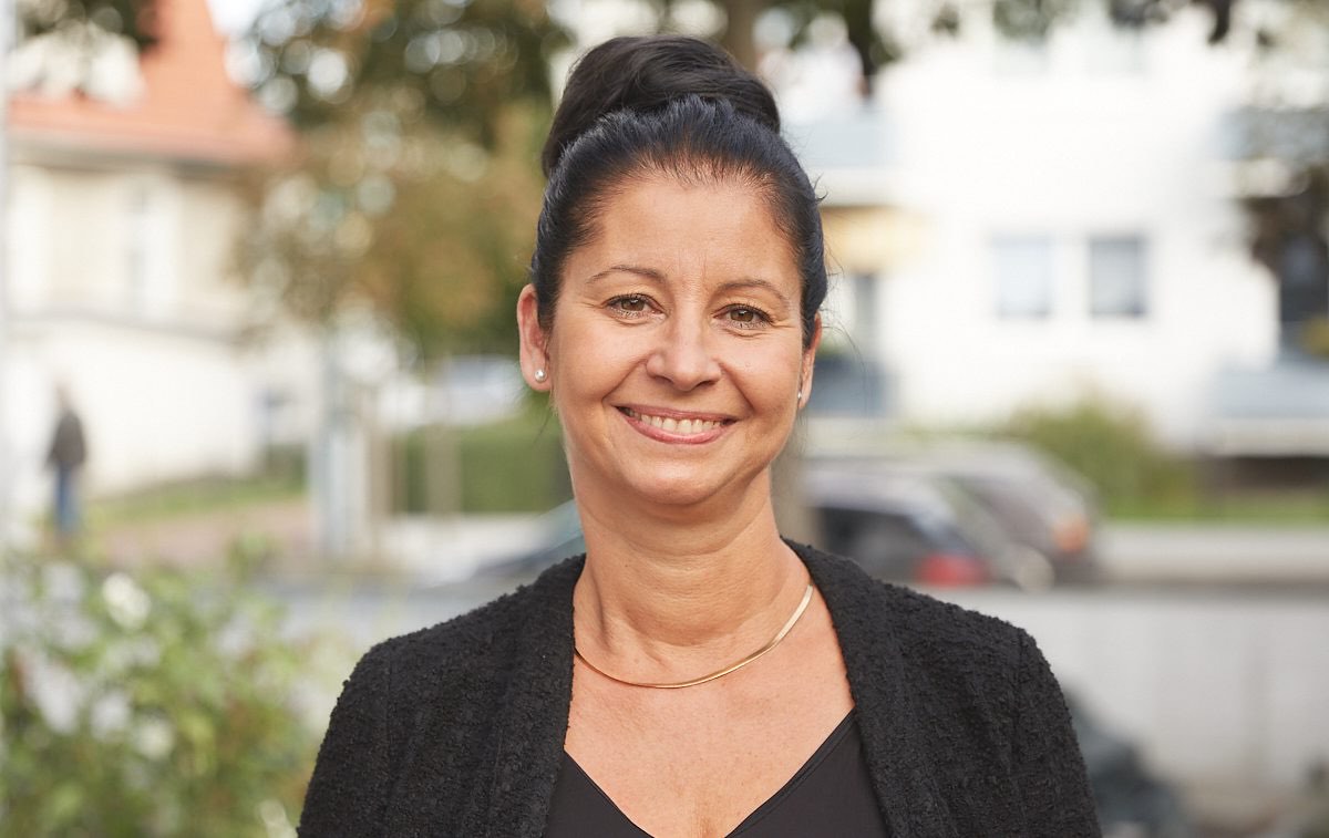 Sandra Sutmar-Girke lächelnd im Freien vor der Kanzlei